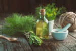 Fresh green dill, fennel seeds, bottle of spirits to make essence