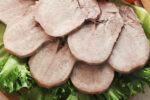 Slices of beef tongue arranged on a platter.