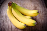 Fresh bananas on wooden table.