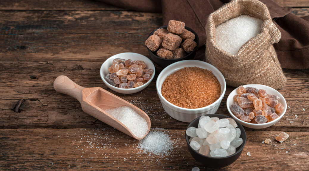 Different types of sugar on a wooden background