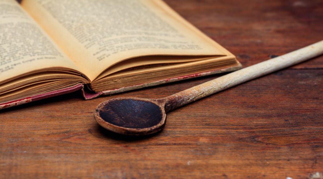 old cookbook and wooden spoon