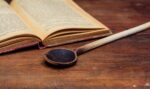 old cookbook and wooden spoon