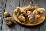 Fresh Jerusalem artichokes on wooden background